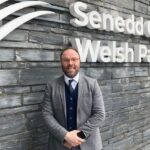 Man outside Welsh Parliament discussing housing white paper and rental sector reforms.