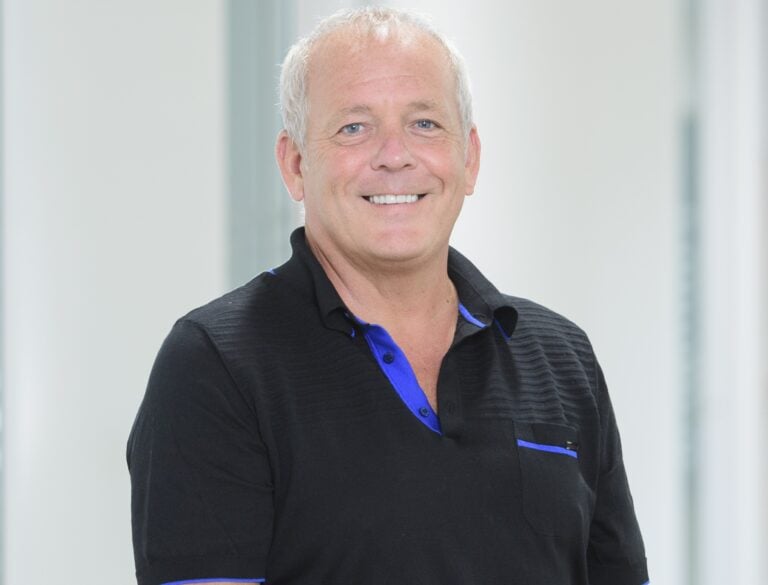 Smiling man standing in a bright hallway related to rising rental market demand