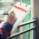 Hand completing a property inventory checklist on a clipboard to support accurate rental inspections