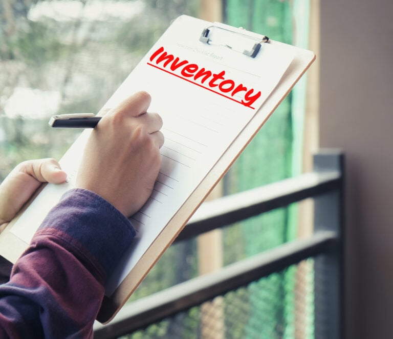 Hand completing a property inventory checklist on a clipboard to support accurate rental inspections