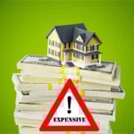 House model on stacks of cash highlighting rising housing costs