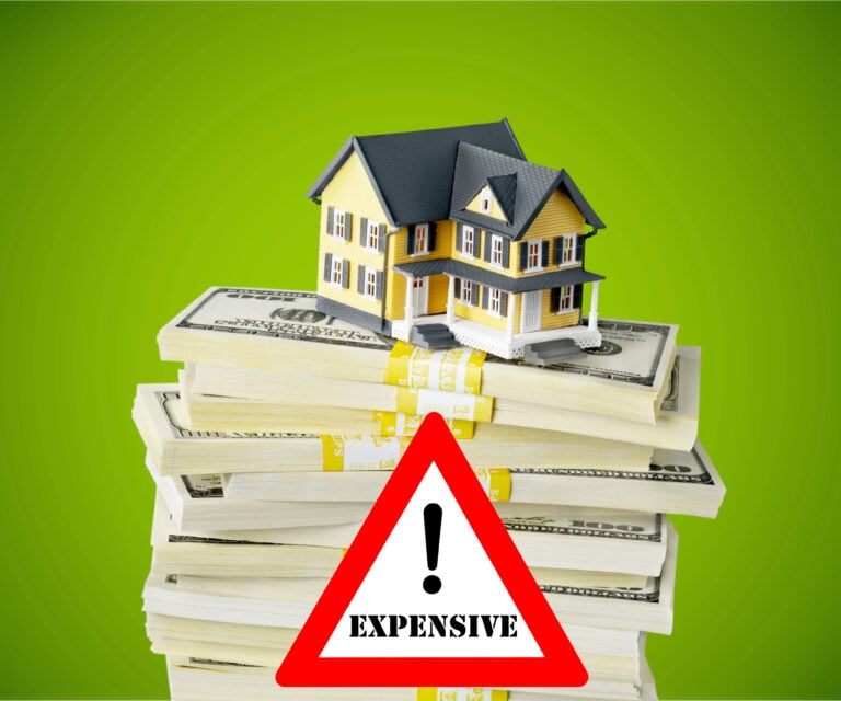 House model on stacks of cash highlighting rising housing costs