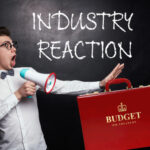 Man reacting to UK Budget announcement with megaphone and red HM Treasury briefcase