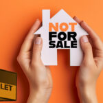 Hands holding paper house labeled “Not For Sale” beside a “To Let” sign, symbolizing landlords retaining rental properties.