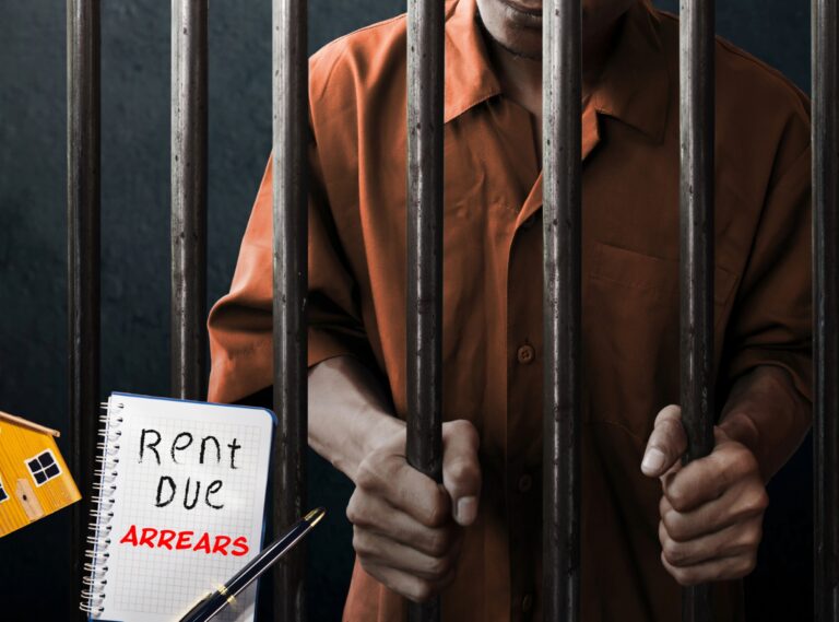 Tenant in prison behind bars with rent arrears note highlighting unpaid rent issue