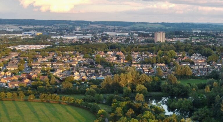 Aerial view of Milton Keynes housing estates surrounded by greenery at sunset
