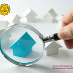 Magnifying glass focusing on a blue house among white houses, symbolising housing inspections and licensing reform