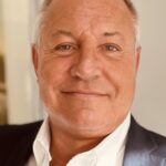 Smiling business professional in a suit representing OpenBrix leadership.