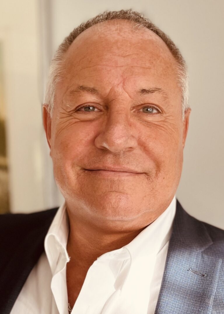 Smiling business professional in a suit representing OpenBrix leadership.