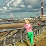 Child overlooking Blackpool beach with tower and pier in view