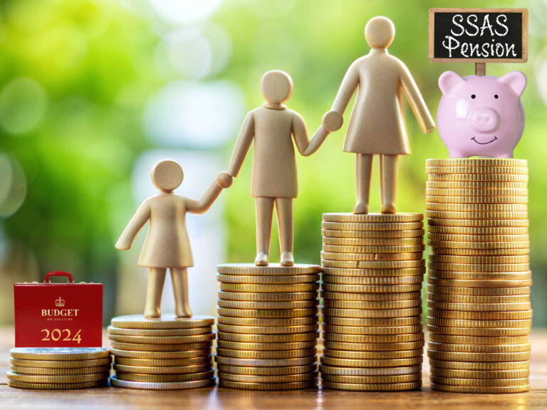 Wooden family figures on stacked coins with piggy bank and SSAS pension sign.
