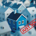 Blue house with a red "Just Sold" stamp representing rising UK property sales.