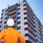 Construction inspector assessing cladding on a high-rise residential building