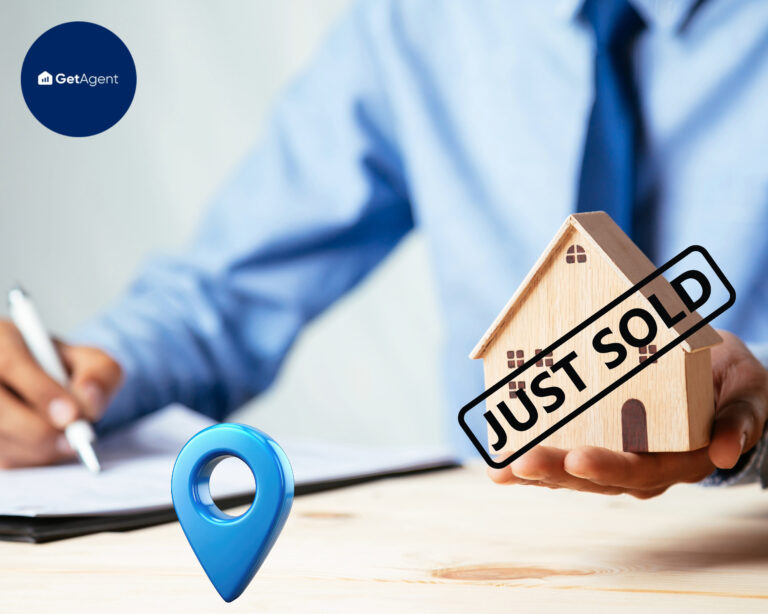 Estate agent holding house model with "Just Sold" sign, symbolizing property sales in 2024
