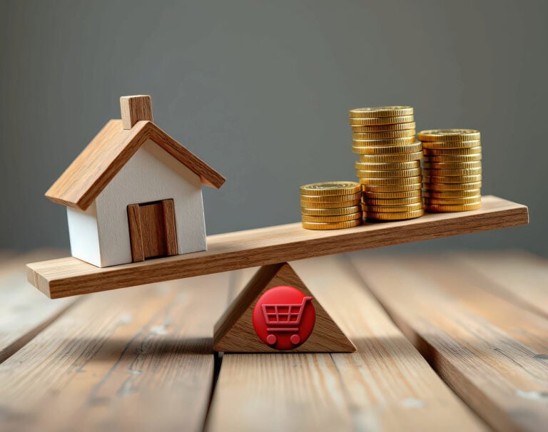 House and gold coins balanced on a wooden seesaw representing property investment leverage