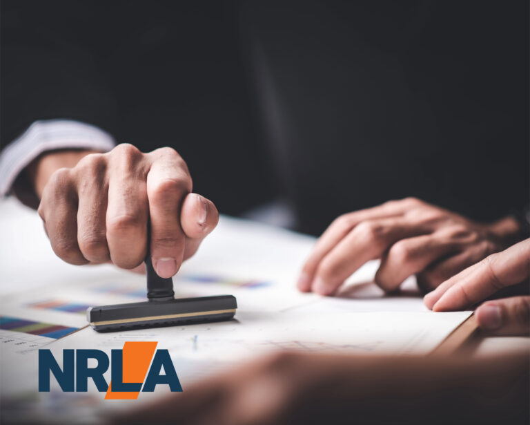 Hand stamping approval on landlord licensing documents with NRLA logo