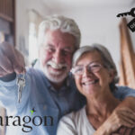 Smiling older couple holding house keys, symbolizing rise in older renters