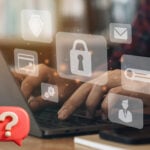 Hands typing on laptop with security icons representing data protection.