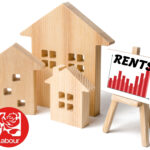Wooden houses with rising rent chart and Labour Party logo.