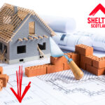 Model house under construction with bricks and blueprints highlighting housing targets in Scotland.