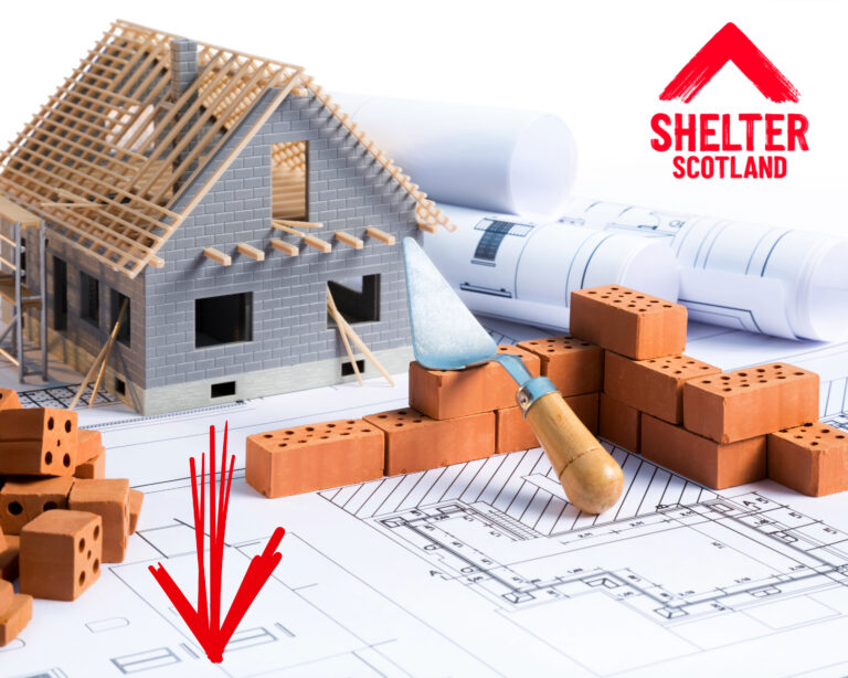Model house under construction with bricks and blueprints highlighting housing targets in Scotland.