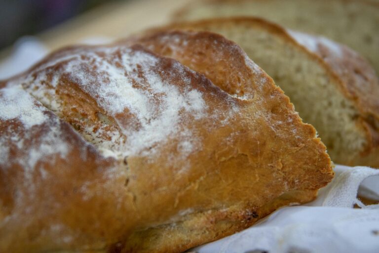 Freshly baked loaf of bread with a golden crust and light dusting of flour.