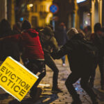Group of people involved in street disorder with eviction notice overlay.