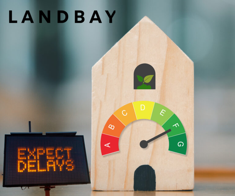 Wooden house model with EPC rating gauge and delay warning sign.