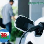 Electric vehicle charging point in use with Welsh policy debate context