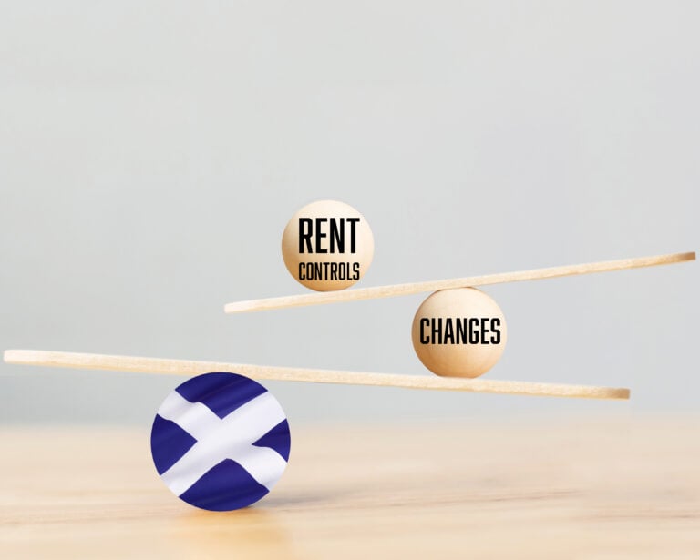 Wooden balance scale with rent control and changes, supported by a Scotland flag sphere.