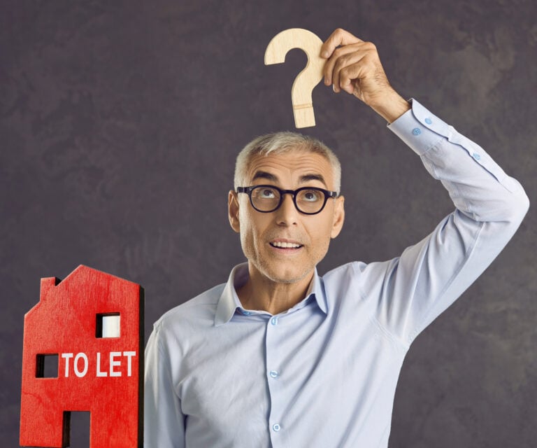 Man holding a question mark above his head beside a model house sign reading "To Let"
