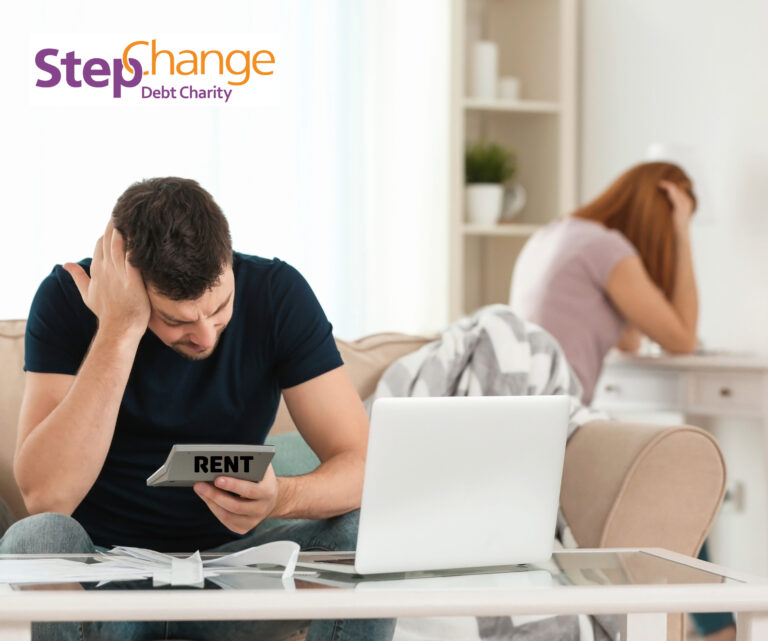 Man stressed over rent payments while partner looks worried in background