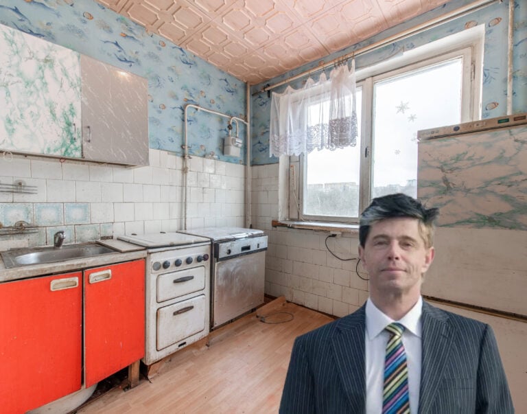 Run-down council kitchen with outdated appliances and housing law expert in foreground