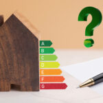 Wooden house model with EPC rating chart and question mark symbolizing energy efficiency concerns