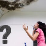 Tenant on phone looking at mould on ceiling, asking for help