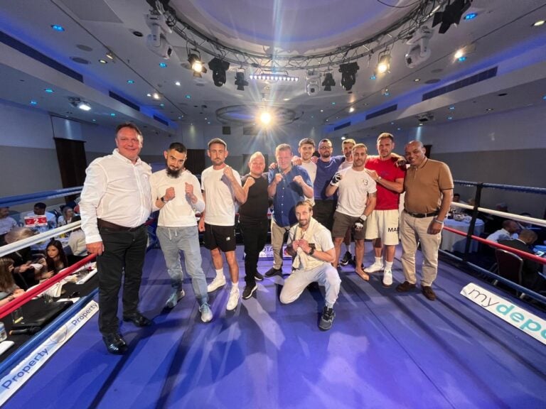 Group of participants and supporters posing in the boxing ring at Rumble with the Agents charity event