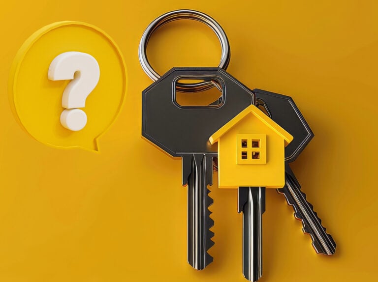Keys with a small house keychain and question mark symbol on yellow background