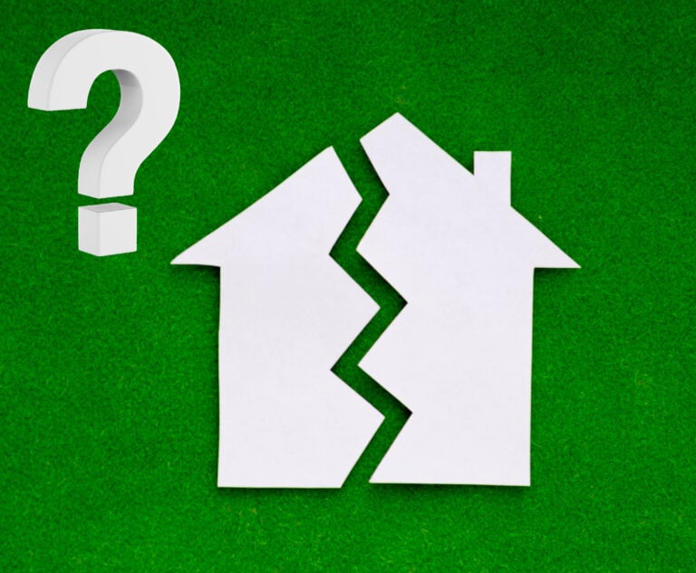 Paper house split in two with a question mark on green background