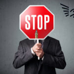 Businessman holding a stop sign highlighting calls to pause UK rental reforms
