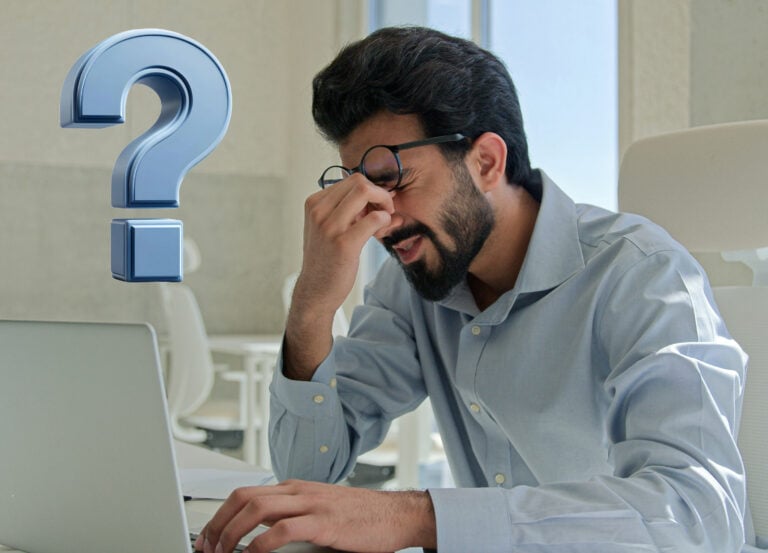 A man sitting at a laptop and a question mark
