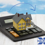 Model house on a calculator with Halifax logo, symbolising UK house price changes.