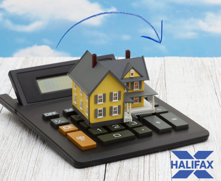 Model house on a calculator with Halifax logo, symbolising UK house price changes.