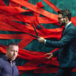 A man cutting red tape