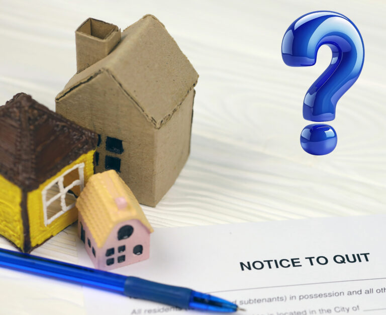 Small wooden model houses and a blue question mark