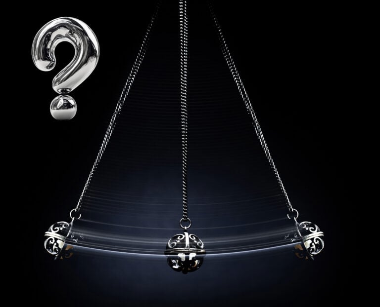 A pendulum swinging and a question mark on a black background