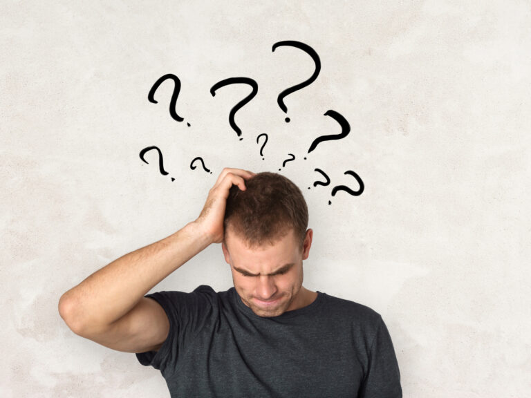 Confused man scratching head with question marks above.