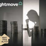 Silhouette of a worried first-time buyer behind stacks of coins, symbolising rising mortgage costs.