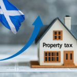 A modle home with an arrow pointing upwads and the Scottish flag