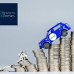 A blue car balancing on stacked coins