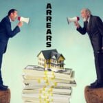 Two men speaking through tannoy systems with houses sitting on papers in between